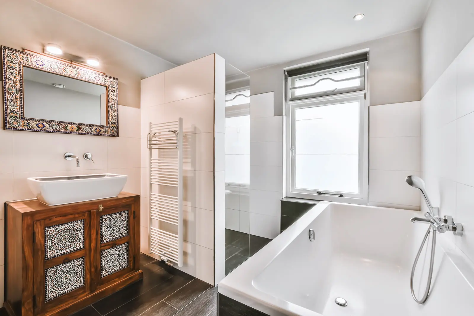 Salle de bains avec baignoire et vasque sur meuble
